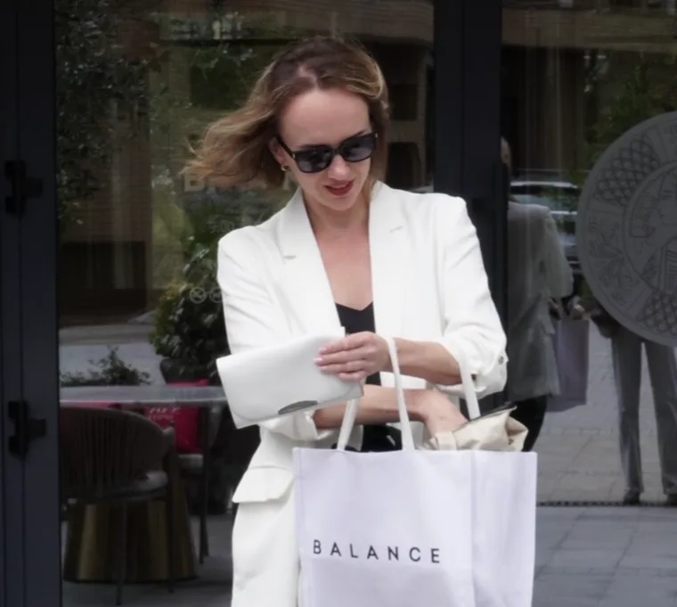 Алена в белом костюме на улице, в руках сумка с надписью BALANCE